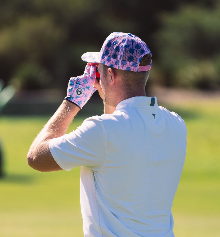 golfer with ranger finder and pink hat and glove